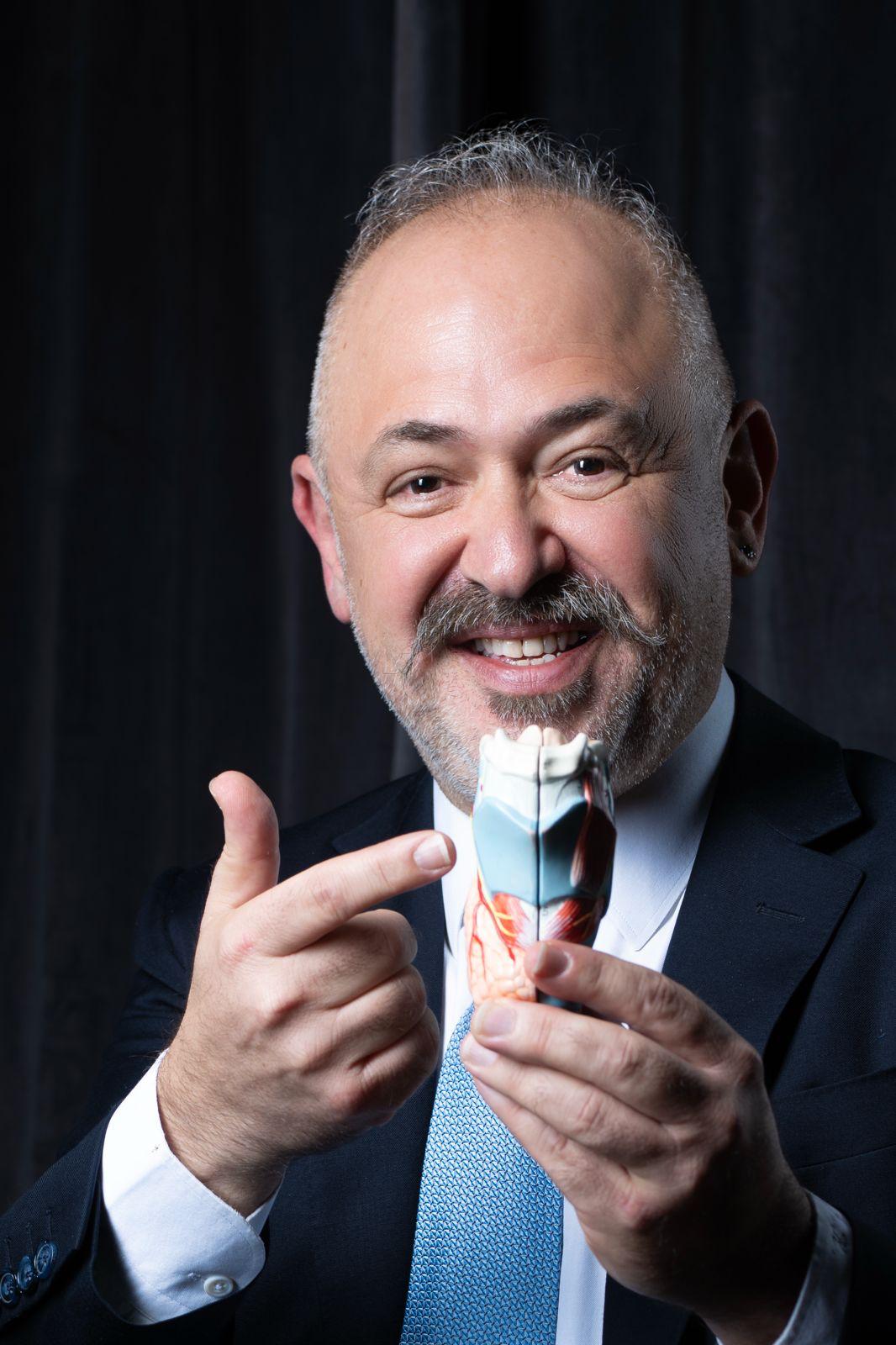 Prof. Dr. İsmail Koçak holding a model of the larynx